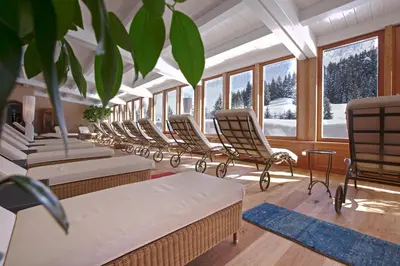 a row of chairs in a room with windows at Sporthotel Floralpina in Alpe di Siusi