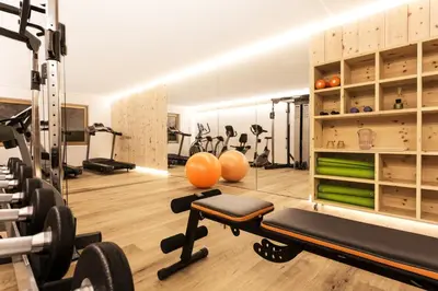 a gym with treadmills and machines in a room at Sporthotel Floralpina in Alpe di Siusi