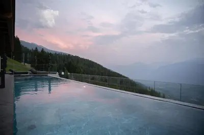 a swimming pool with a view of a mountain at Mountain Lodge Prennanger in Schenna