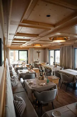 a dining room with tables and chairs and windows at Mountain Lodge Prennanger in Schenna