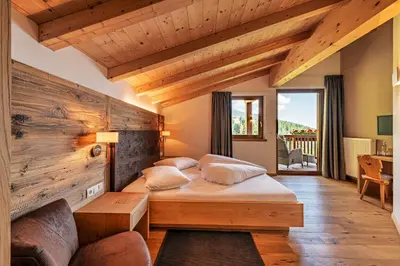 a bedroom with a bed and a wooden wall at Mountain Lodge Prennanger in Schenna