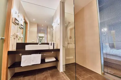 a bathroom with two sinks and a tub and a mirror at Hotel Belvedere - Adults Only - 14 plus in Naturno