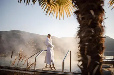 a woman in a robe standing on a rail at Lake Spa Hotel SEELEITEN in Caldaro