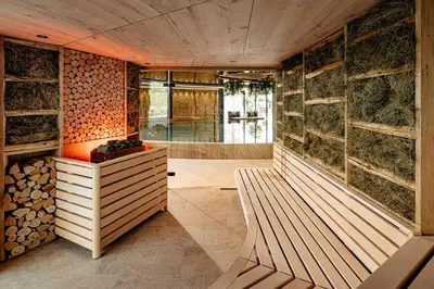 a room with a bench and a bunch of logs at Lake Spa Hotel SEELEITEN in Caldaro