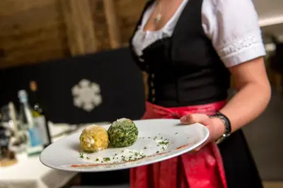 a woman holding a plate with food on it at Alpstyle Hotel Albolina Wellness & Beauty in Canazei