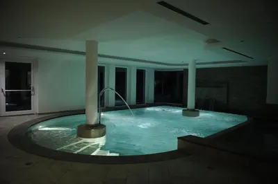 a large swimming pool in the middle of a building at Alpstyle Hotel Albolina Wellness & Beauty in Canazei