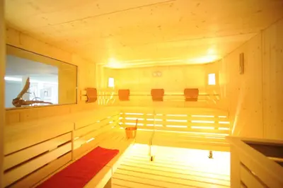 an empty sauna with a person sitting in it at Alpstyle Hotel Albolina Wellness & Beauty in Canazei