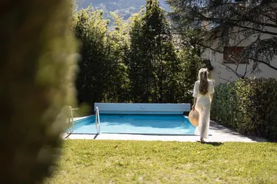 a woman standing in front of a swimming pool at Weingarten Terlan - Rooms & Breakfast in Terlano
