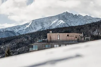 a building on a hill with mountains in the background at Hotel Ambet in Maranza