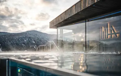 a swimming pool with a mountain in the background at Hotel Ambet in Maranza