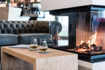 two glasses of beer on a table next to a fireplace at Hotel Ambet in Maranza