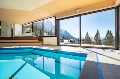 a house with a swimming pool with a view of mountains at Hotel San Martino in San Martino di Castrozza
