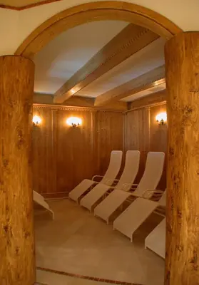 a row of white chairs in a room with wooden walls at Hotel San Martino in San Martino di Castrozza