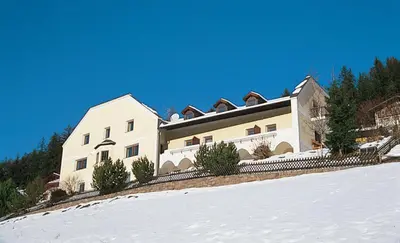 a large white building on top of a snow covered hill at Residence Granvara in Ortisei