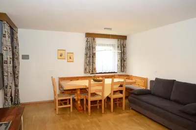 a living room with a wooden table and a couch at Residence Granvara in Ortisei