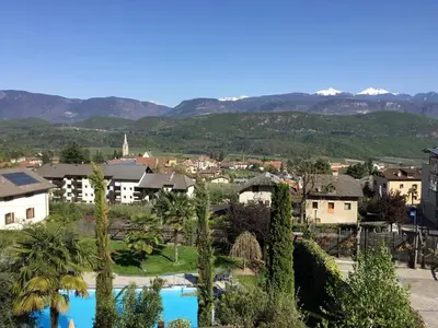 a view of a city with mountains in the background at Garni Brunnenhof in Caldaro