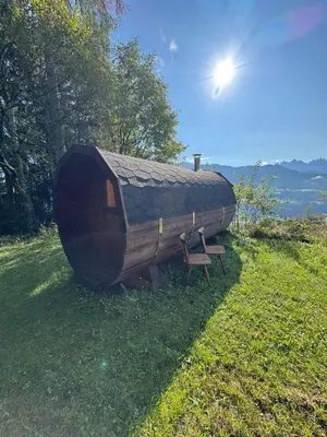 a large wooden cabin with a bench in the grass at Biogasthaus Plonerhof 
