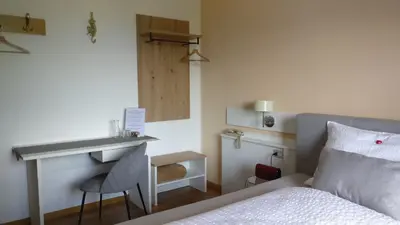 a bedroom with a bed with a desk and a bed sidx sidx sidx at Biogasthaus Plonerhof 