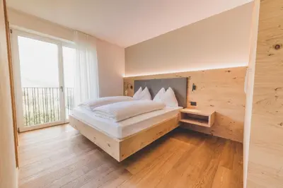 a bedroom with a bed and a large window at Sinnergut in Nalles