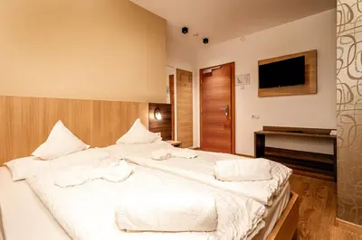 a large white bed in a room with a television at Hotel Klammer in Vipiteno