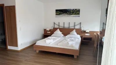 a bedroom with a bed with white sheets and pillows at Hotel Klammer in Vipiteno