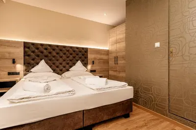 a bedroom with a large bed with white pillows at Hotel Klammer in Vipiteno