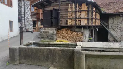 a building with a pile of wood in front of it at Lausen Vil in Canale San Bovo