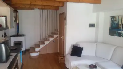 a living room with a white couch and stairs at Lausen Vil in Canale San Bovo