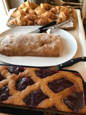 a table with two plates of pie and other pastries at Garnì La Dorada in Colfosco