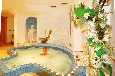 a woman in a jacuzzi tub in a room at Hotel Funggashof in Naturno