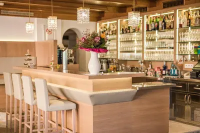 a bar with a vase of flowers on a counter at Hotel Funggashof in Naturno