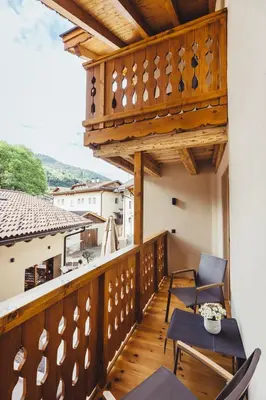 a balcony with chairs and a table on a building at Hotel Schmuckhof in Chiusa