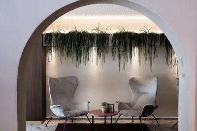 two chairs and a table with plants on a wall at Hotel Erzherzog Johann in Schenna