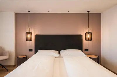 a bedroom with a large bed with two white pillows at Hotel Erzherzog Johann in Schenna