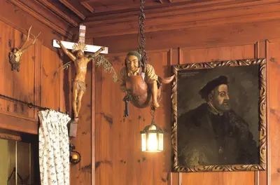 a crucifix hanging on a wall with a painting and a cross at Hotel Zum Turm in Castelrotto