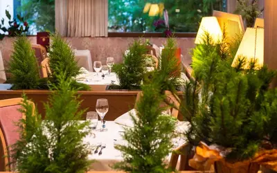 a table with wine glasses and trees on it at Hotel Zum Turm in Castelrotto