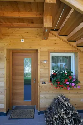a wooden house with a door and a window at Residence Ciasa Mirasas in Badia