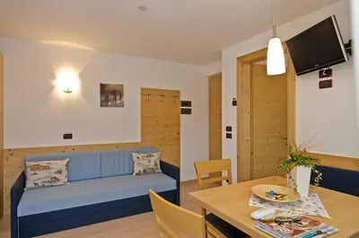 a living room with a blue couch and a table at Residence Ciasa Mirasas in Badia
