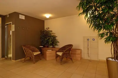 two chairs and a table in a room with plants at Residence Ciasa Mirasas in Badia