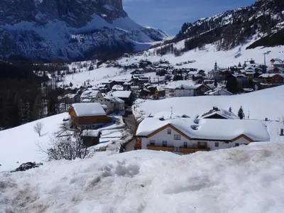 a village covered in snow on a mountain at Pensione Vittoria in Colfosco