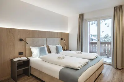 a bedroom with a large bed with two stuffed animals on it at Apartment Villa Stefania in Selva di Val Gardena