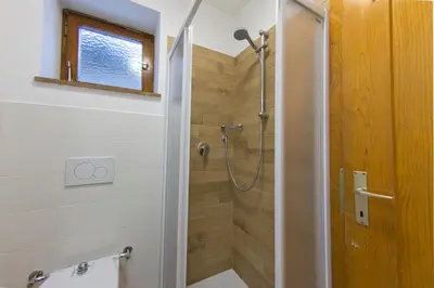 a bathroom with a shower with a glass door at CasaMau Studio in Campitello