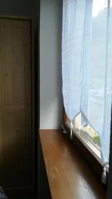 a window with a white curtain and a wooden floor at CasaMau Studio in Campitello
