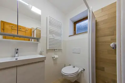 a bathroom with a toilet and a sink and a window at CasaMau Studio in Campitello