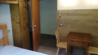 a bedroom with a table and a wooden table and chair at CasaMau Studio in Campitello