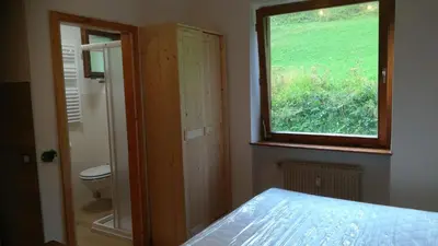 a bedroom with a window and a bed and a toilet at CasaMau Studio in Campitello