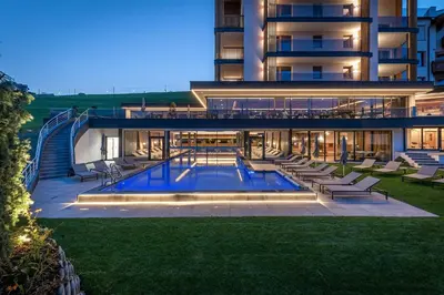 a large building with a swimming pool in front of it at Hotel Edelweiss in Maranza