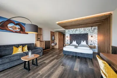a hotel room with a bed and a couch at Hotel Edelweiss in Maranza
