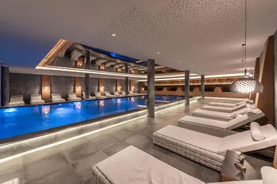 a swimming pool in a building with a swimming pool at Hotel Edelweiss in Maranza