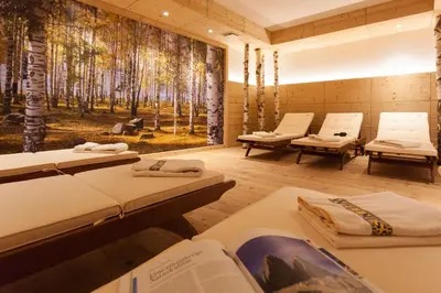 a room with three beds and a forest mural at Hotel Erika in Braies